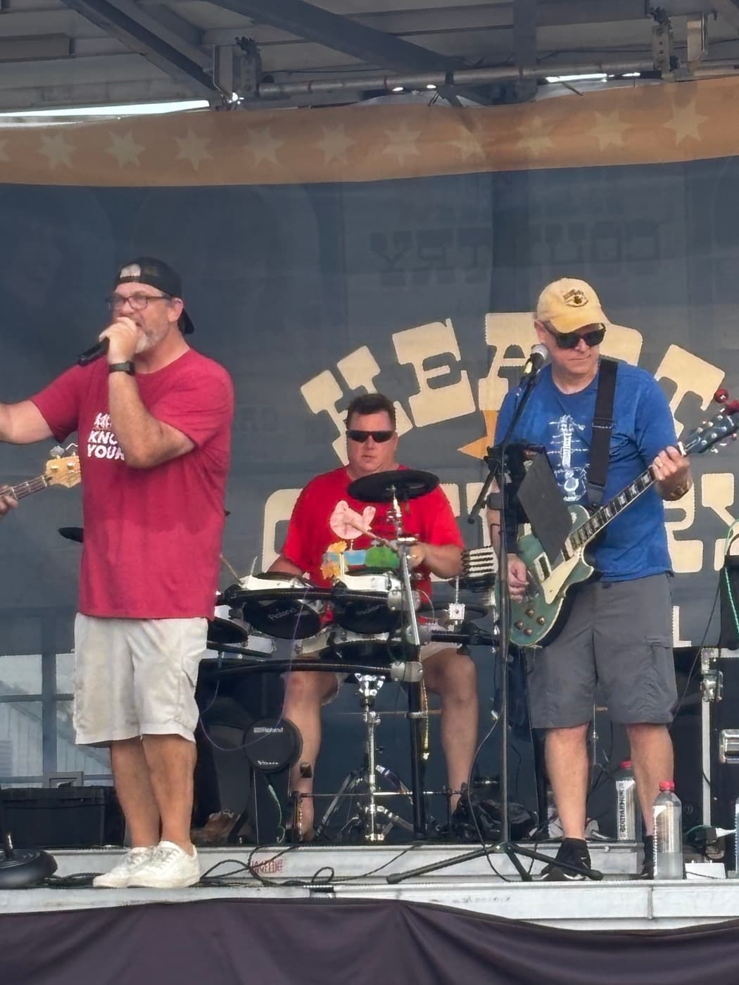 Singer at the mic with the drummer and a guitarist at the Kenton County Fair