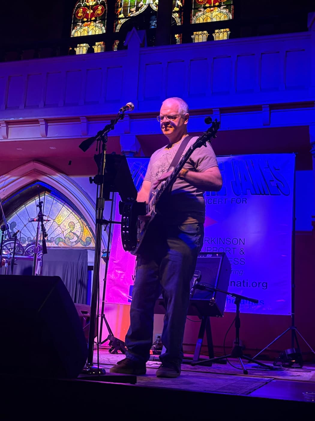Guitarist singing into the mic under purple stage light at Rock on the James